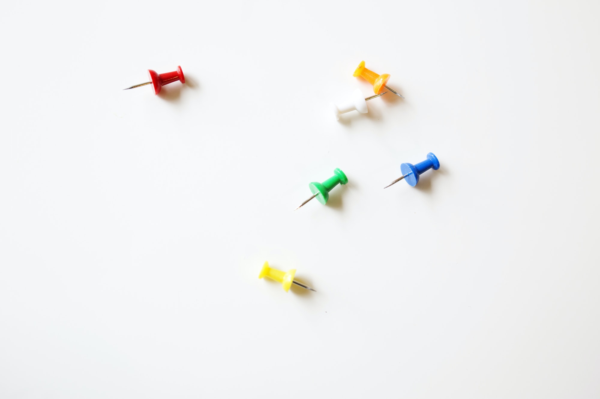 Bright colored pushpins on a white table