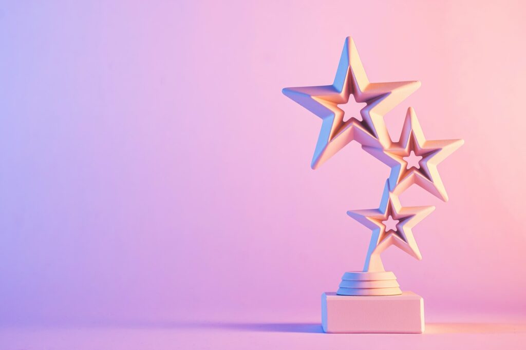Three star trophy award on gradient pink background