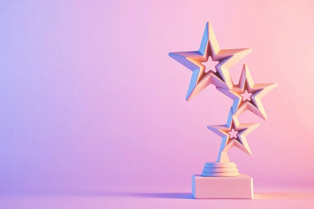 Three star trophy award on gradient pink background